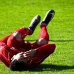 Photo of soccer player with knee injury. Knee giving way on field of play. Click Physiotherapy